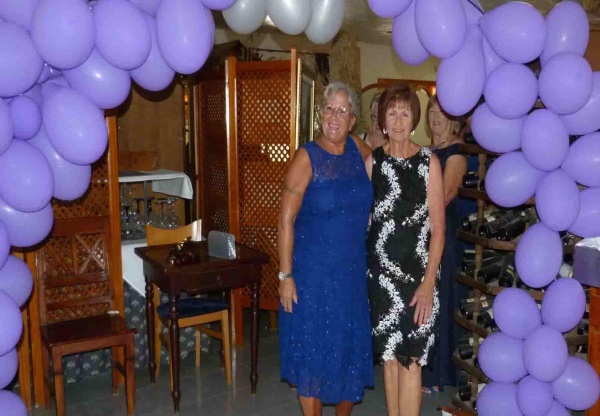 2 ladies surrounded by a balloon arch