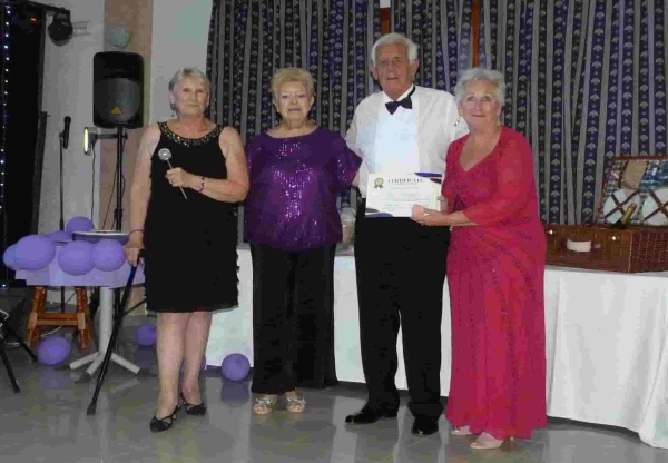 2 ladies presenting an award to a gentleman and a lady