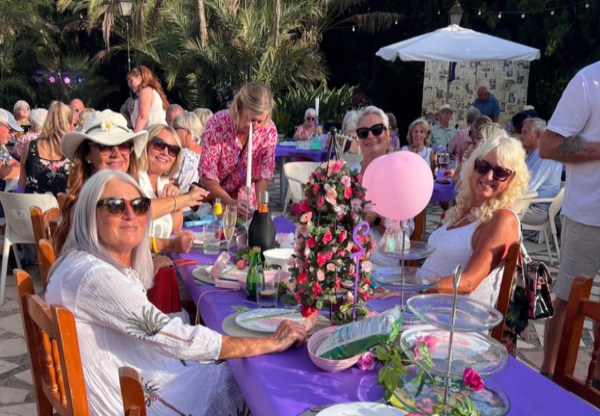 people sitting at tables outside, eating and drinking