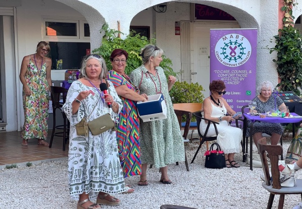 ladies in colourful summer dresses with MABS logo in the background