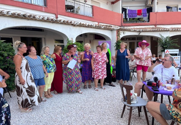 ladies standing in a line, wearing colourful clothes